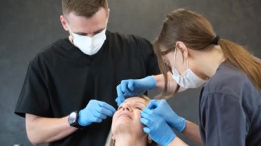 İki doktor yaşlı bir kadını estetik ameliyat için hazırlıyorlar. Hastaların modern estetik ameliyatları