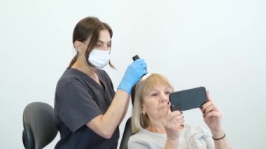 Trichological ve kozmetik kliniğinde bir kadın hastada kafa derisi ve saç köklerinin dermatolojik muayene.