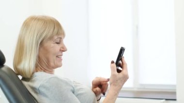 Avrupalı büyükannem bir video görüşmesinde akıllı telefon cihazıyla iletişim kuruyor. Aileyle video bağlantısı