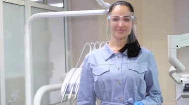 Güzel gülümseyen kadın dişçi baş parmağını gösteriyor. Çok klas ve süper bir jest. Modern diş kliniği. Diş tedavisi kavramı.