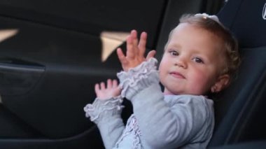 Mutlu kız elleriyle bir şeyler göster. Küçük tatlı kız alkışlar yapıyor..