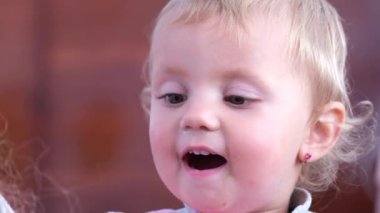 Çekici bir çocuk mutlu bir şekilde oynuyor. Oyuncaklarla eğlenen bir kızın yakın çekimi. Küçük tatlı kız bebeğine sarılıyor.