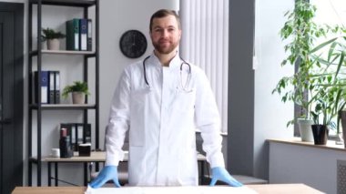Modern bir Amerikan kliniğindeki yakışıklı bir doktorun portresi. Genç bir stajyer doktor kameraya bakıp gülümsüyor..