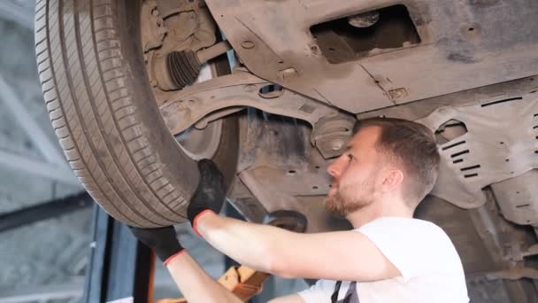 Mekaniker Kontrollerar Ett Bilhjul Bilmekanikern Reparerar Bilens Fjädring Garaget Byter — Stockvideo