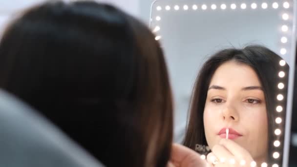 一个漂亮的黑发女孩在美容院化好妆之后 在镜子里惊讶极了 现代美容院的女人 — 图库视频影像
