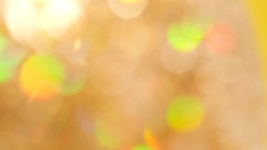 Altın rengi bulanık Noel arkaplanı, odağını kaybetmiş tatil ışıkları. Yeni yıl konsepti. Yüksek kalite 4k video