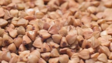 Makro çekim, kuru kahverengi karabuğday Groats, dönen video arkaplan - üst görünüm. 4k video