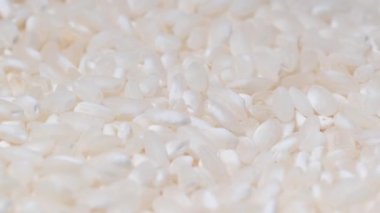 Japon çiğ pirincinin bir tabakta dönüşünü yakından çek. Beyaz pirinç video arka plan yiyecek, video makro