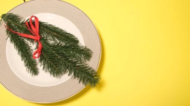 Sarı arka planda bir tabakta yeni yıl süsü. Yeni yıl ve Noel tatili konsepti. 4k video