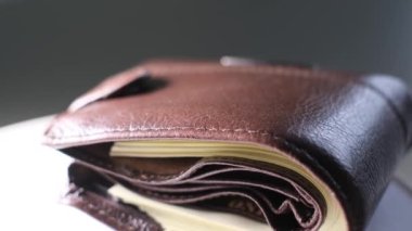 Siyah arka planda dolar banknotları olan kahverengi bir cüzdanı kapat. Finansal harcamalar, harcamalar, alımlar, birikmiş tasarruflar. 4k video