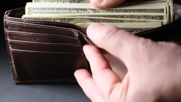 Hombre Sostiene Una Cartera Marrón Con Billetes Dólar Los Cuenta — Vídeo de stock