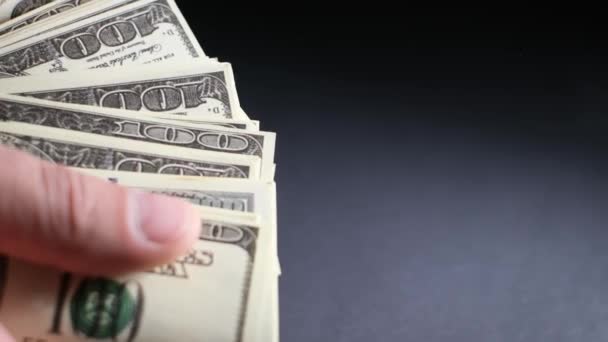 黒の背景に100ドル札を数える男性の手の終わり 男は多くのドルを示しています 4Kビデオ — ストック動画