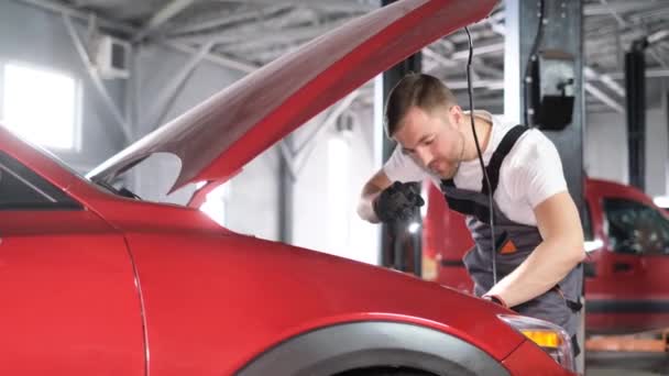 在汽车修理厂检查一辆现代汽车的技师 车间的汽车技工 — 图库视频影像