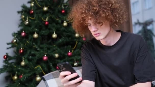 Curly Ung Kille Orolig Att Hålla Smartphone Sina Händer Han — Stockvideo