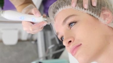 Hardware procedure of cleaning, peeling and deep moisturizing of the skin of the face. Beautiful woman at the beautician