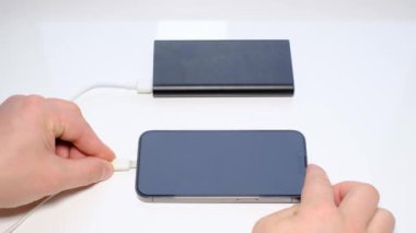 Connecting a mobile phone to an external power bank battery, charging a smartphone. 4k video