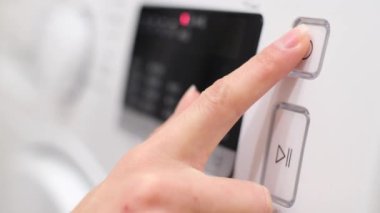 Setting the program panel of the washing machine for washing clothes. Washing machine display during washing. Close up