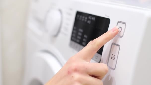 洗濯機をオンにする女性の手のクローズアップ 洗濯服だ 作動中の洗濯機 4Kビデオ — ストック動画