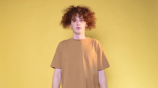 Surprised Curly Haired Guy Spreads His Hands Looks Camera Yellow — Video Stock