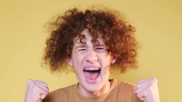 Kudrnatý Muž Ukazuje Bláznivou Radost Izolované Žlutém Pozadí Studiu Radostné — Stock video