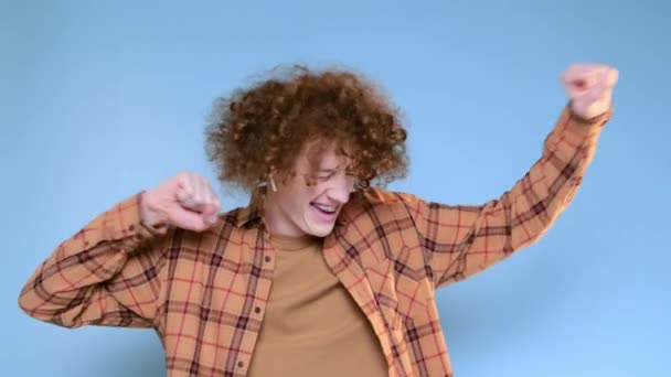 Kıvırcık Kızıl Saçlı Mavi Arka Planda Dişlek Gülüşlü Dikkatsizce Dans — Stok video