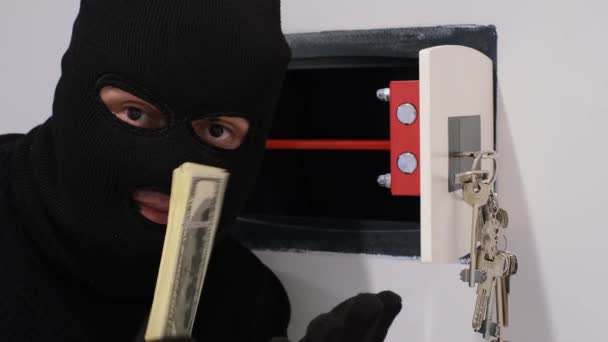 黒いマスクの強盗が金庫を開けて金を盗む 泥棒アパートだ 金庫をハッキングしてる 4Kビデオ — ストック動画