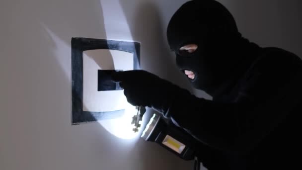 一个戴着黑色面具的男人闯入银行金库打开保险柜 强盗从保险柜里偷钱 银行储蓄面临风险 — 图库视频影像