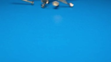Close-up shot of carpenter screws on a blue background. Metal screws on the table. Construction goods concept