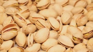 Delicious pistachios in the shell rotate in a circle. Beer snack food concept. 4k video