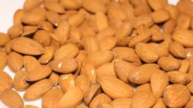 Raw almonds in shell in a white bowl. Concept of healthy eating and raw food. Vegan food. 4k video