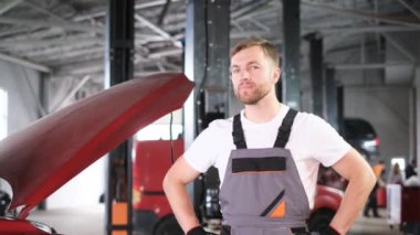 Portrait of a professional mechanic looking at the camera and smiling. The concept of car repair in the USA