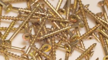 Metal self-tapping screws and screws rotate on the table. Close up. Construction goods concept.
