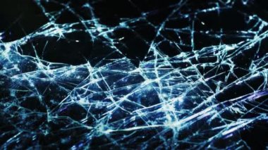 Background of broken glass on a black background. Broken glass with many cracks illuminated by light. Video macro shooting