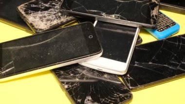 Close-up of used smartphones with a broken screen. Repair of smartphones. Disposal of gadgets.