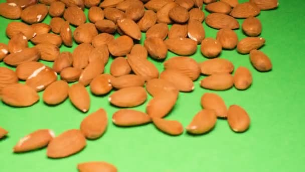 杏仁坚果落在绿色的背景上 坚果健康食品 慢动作 — 图库视频影像