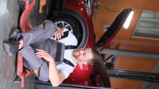 Vertical Video Car Mechanic Talking Smartphone Car Owner Electric Vehicle — Stock Video