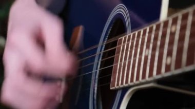Close-up of learning to play the acoustic guitar. A creative musician plays a melody. 4k video