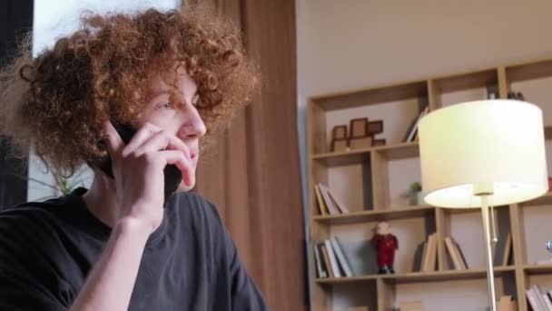 Guy Curly Hair Sitting Sofa Laughing Talking Smartphone Use Mobile — Vídeo de stock