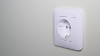 Close-up of a womans hand turning on the power in an electrical outlet. 220 volt outlet.
