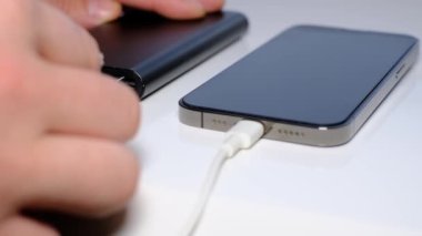 Close-up of charging a smartphone from a Power Bank. Phone charging port. We turn on the charging of the phone by wire.