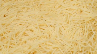 A pile of raw yellow pasta spins in a circle. Flour products. Macaroni. Vegetarian food.