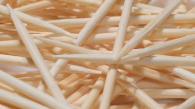 A pile of white wooden toothpicks. Macro video. Texture. Movement in a circle.