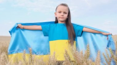 Ukrainian child in a wheat field with a blue and yellow flag of Ukraine. Ukraines victory in the war. Independence Day of Ukraine