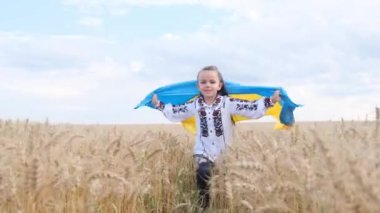 Ukrainian child in a wheat field with a blue and yellow flag of Ukraine. Ukraines victory in the war. Independence Day of Ukraine