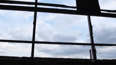 Silhouette of a man singing against the background of a dark blue sky. A man near a large window. Dark rainy clouds in the frame