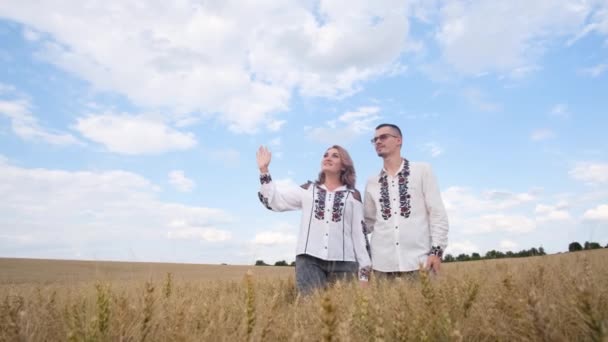 ウクライナ独立記念日 刺繍入りのドレスの家族は 小麦畑の真ん中でウクライナの国歌を歌います 自由の国 — ストック動画