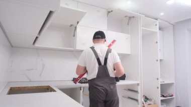 A service technician installs fittings in the kitchen using a water level. High quality 4k video