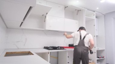 A young man is doing a funny dance while holding tools in his hands. Time to repair the house. Happy man