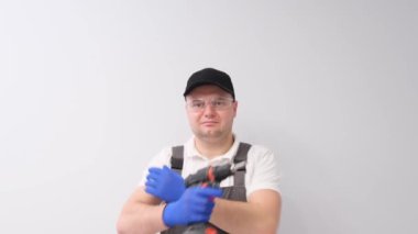 Portrait of construction worker with electric drill on white background in studio. House repair. 4k video