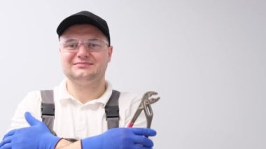 Portrait of a car mechanic holding a wrench on a white background. Professional car repair master. 4k video